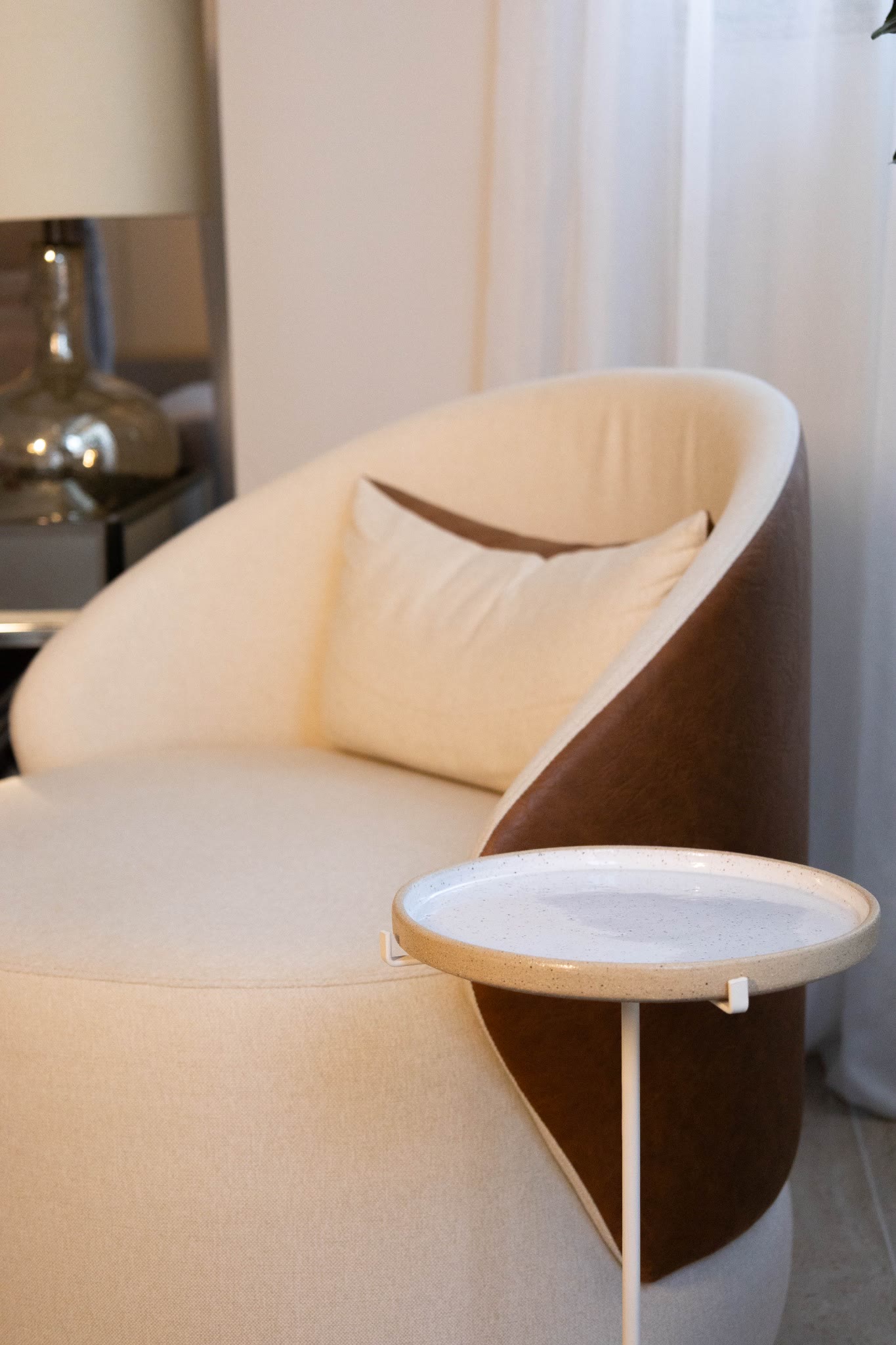 Poltrona estofada em linho com detalhe lateral em couro